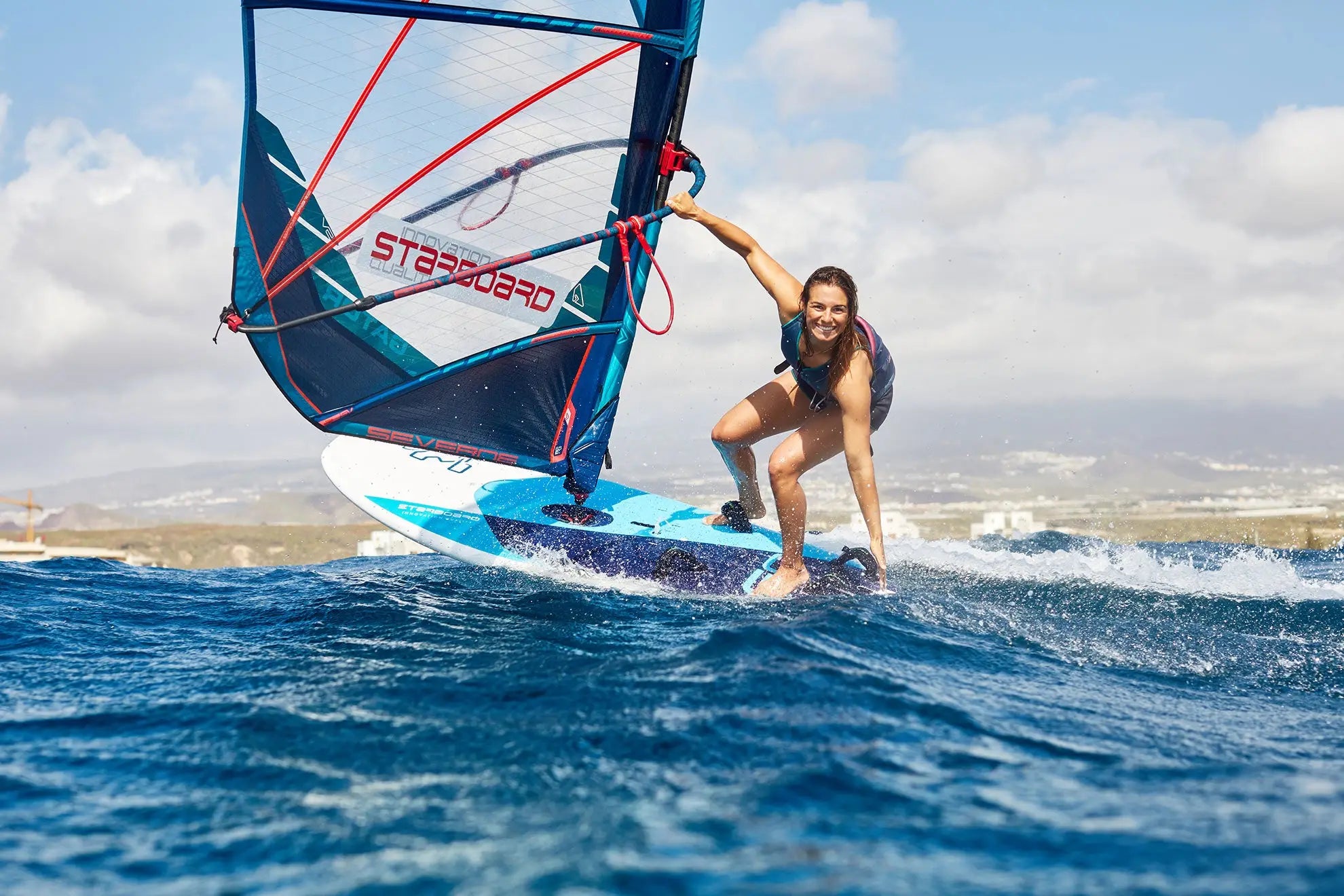 Starboard blue and white freeride windsurf board with teal sail