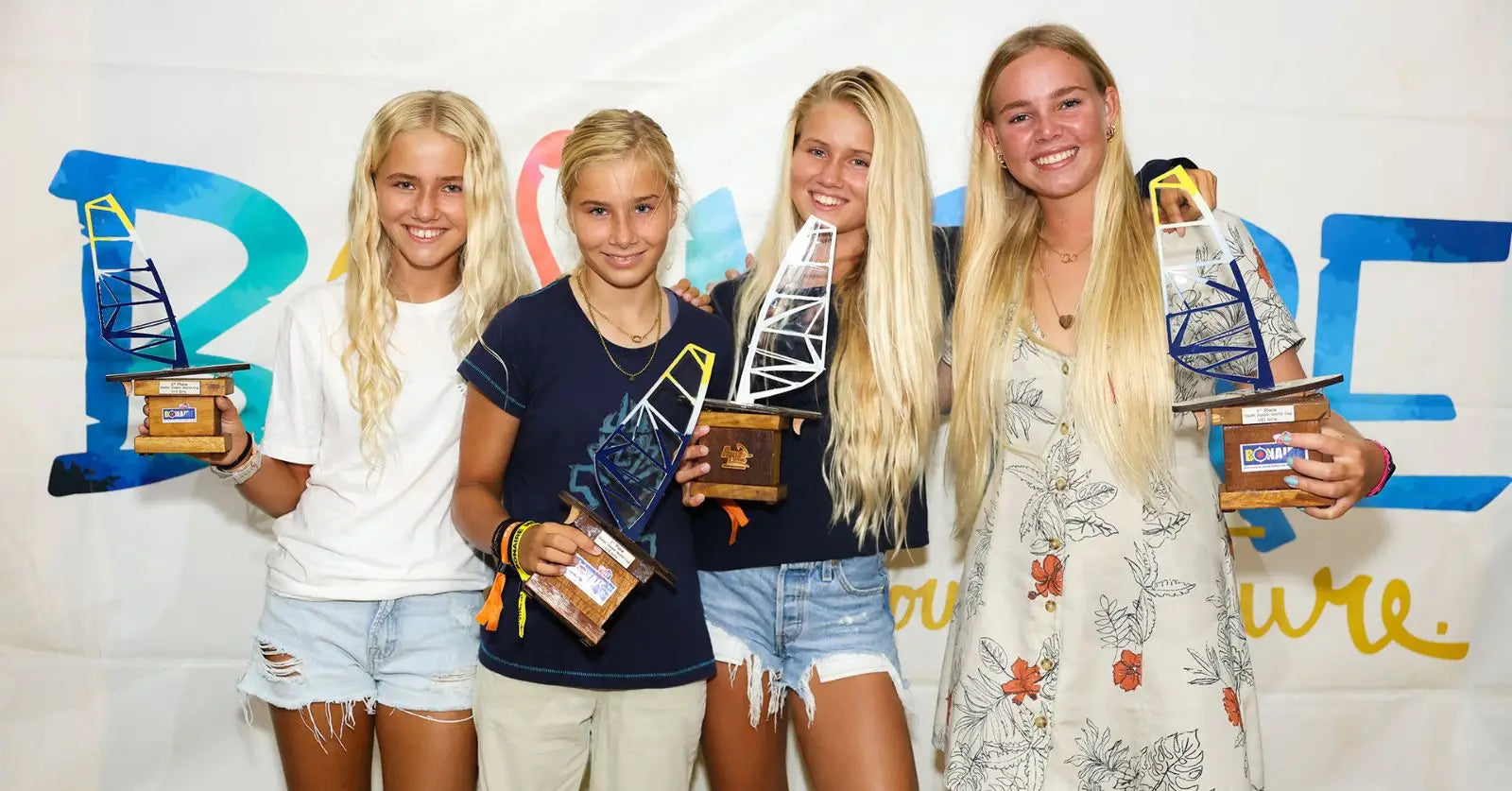Gold trophy with blue and white design atop glass, from Bonaire PWA Youth Slalom World Cup