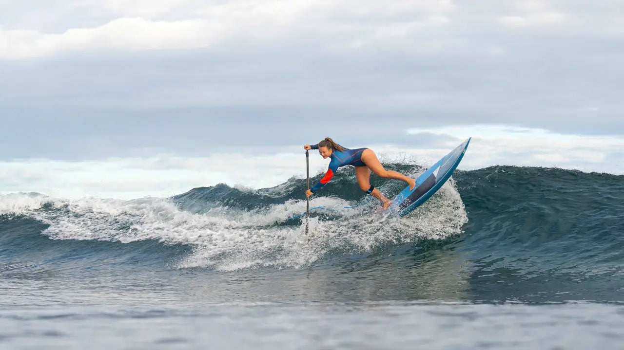 Blue Starboard Spice surfboard with white fins and black leash for pro surfing