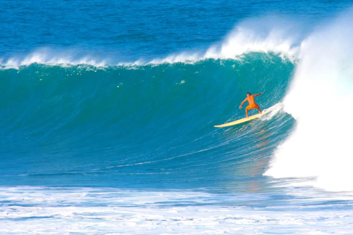 Yellow surfboard with orange white design in Felipe Pomar surf adventures
