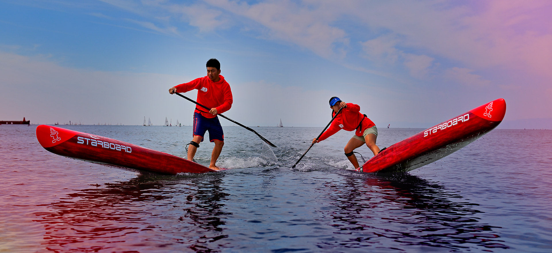 Blue stand-up paddleboard with white and red accents in Hard Paddleboards
