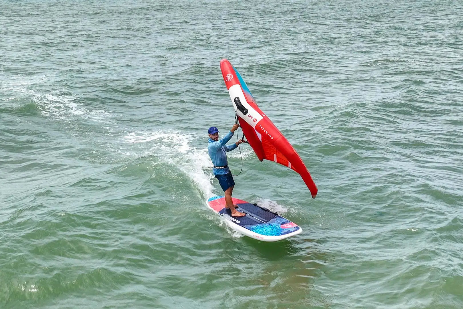 Red and white windsurfing sail with blue trim in Entry-Level Wingboards