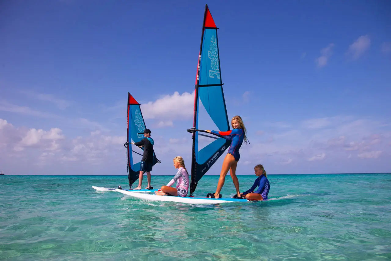 Windsurfing board with red blue sail white deck black fins
